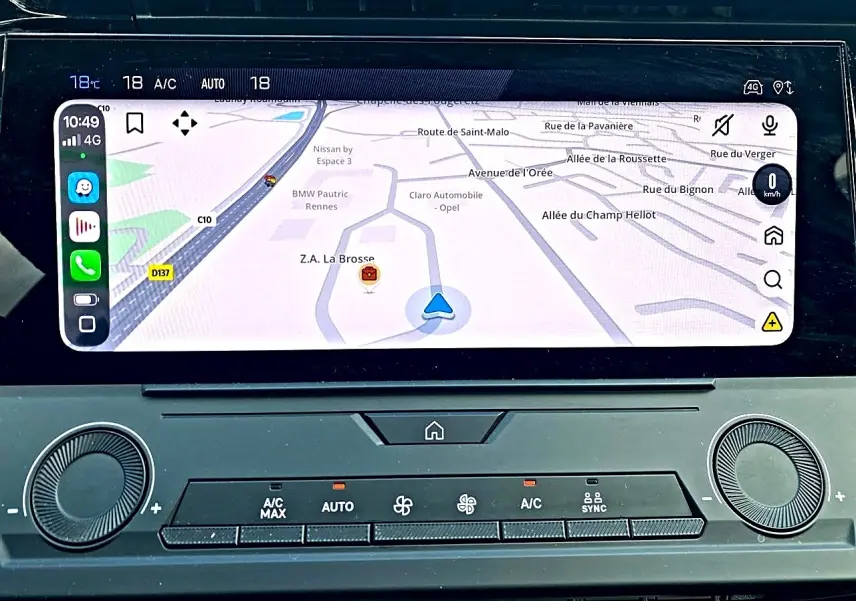 Vue rapprochée de l’écran tactile central du Peugeot 308 gris 2025 affichant la navigation GPS et la climatisation automatique.