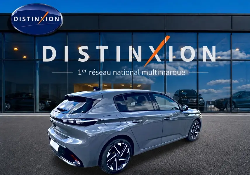 Vue 3/4 arrière droite d'une Peugeot 308 gris métallisé 2025 avec jantes alliage et feux arrière LED distinctifs.