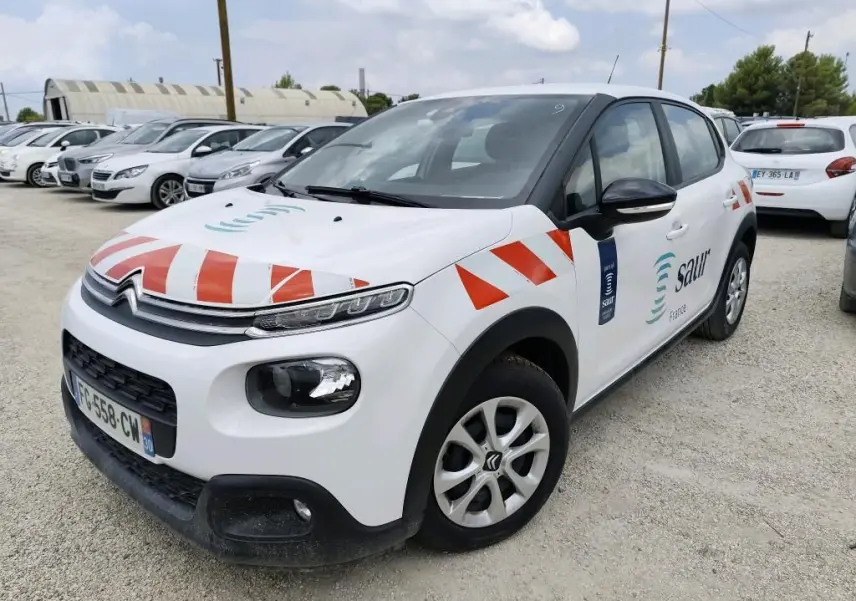 Citroën C3 Société blanche vue 3/4 avant droit avec marquages rouges et logo Saur sur porte.