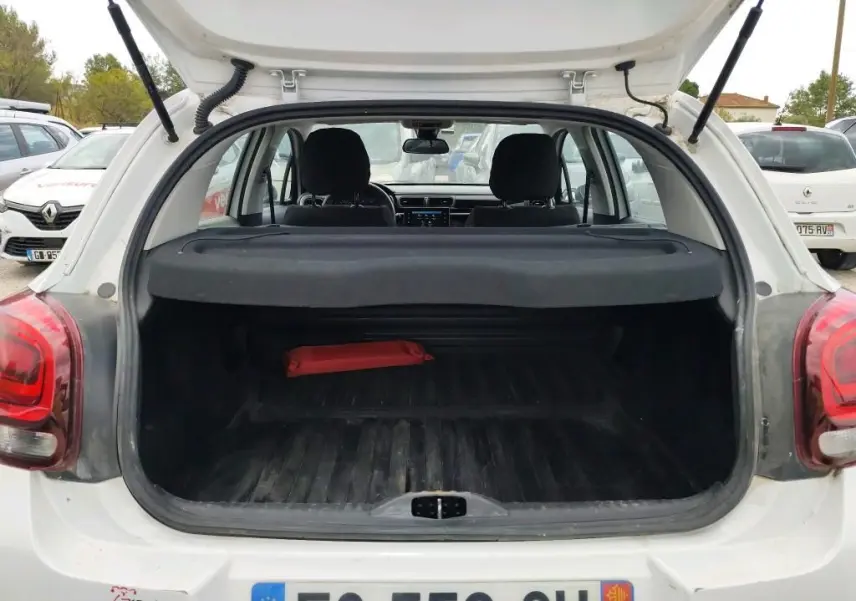 Coffre ouvert vu de l'arrière d'une Citroën C3 Société blanche, montrant l'espace de chargement et l'intérieur.