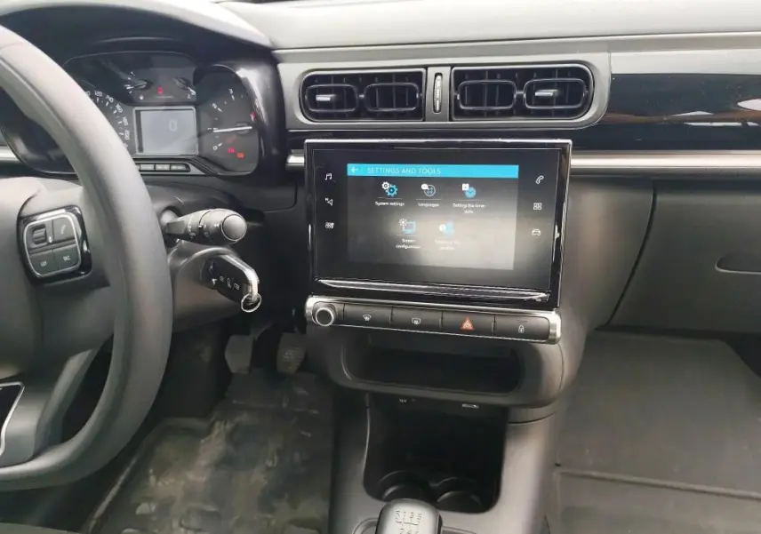 Vue intérieure côté conducteur du tableau de bord noir de la Citroën C3 Société 2019 avec écran tactile et boîte manuelle.