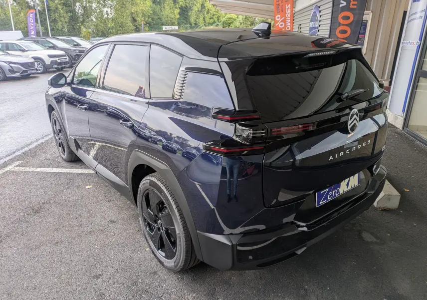 Vue 3/4 arrière droite du Citroën C5 Aircross hybride bleu Eclipse avec toit noir et jantes noires.
