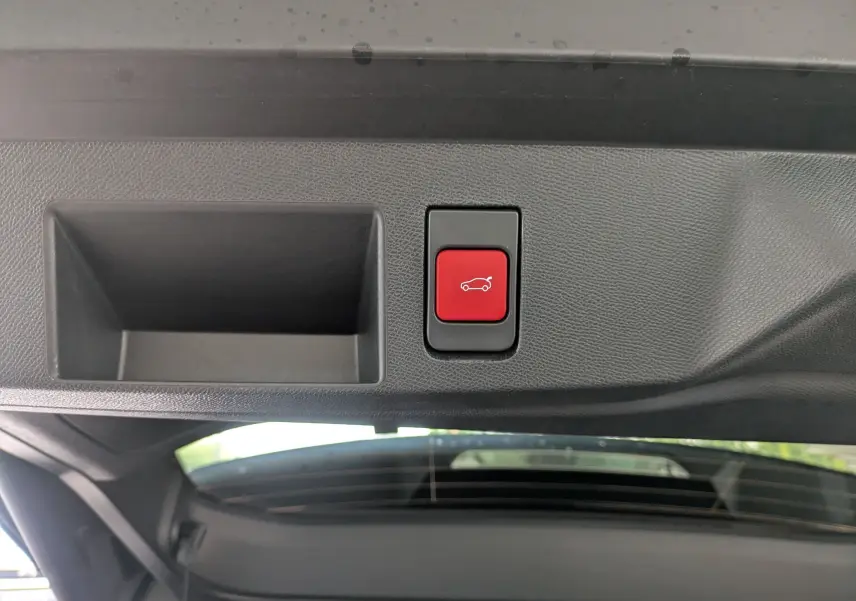 Bouton rouge d'ouverture électrique du coffre sur le hayon intérieur d'un Citroën C5 Aircross hybride bleu Eclipse.