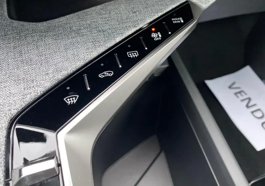 Gros plan sur la console centrale de la Peugeot 3008 Hybrid 2026, montrant les commandes tactiles du système de climatisation.