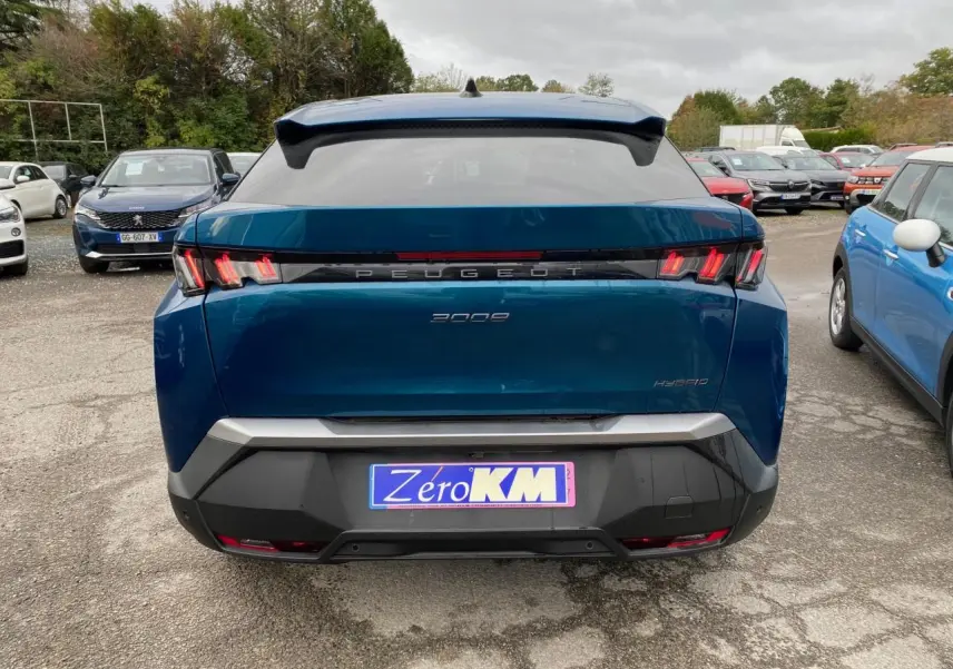 Vue arrière d’un Peugeot 3008 hybride bleu Obsession avec feux arrière à trois griffes et logo central lumineux.