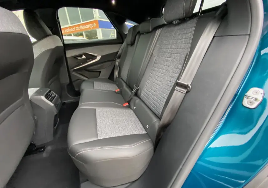 Vue intérieure côté droit des sièges arrière gris et noir du Peugeot 3008 Bleu Obsession avec ceinture de sécurité attachée.