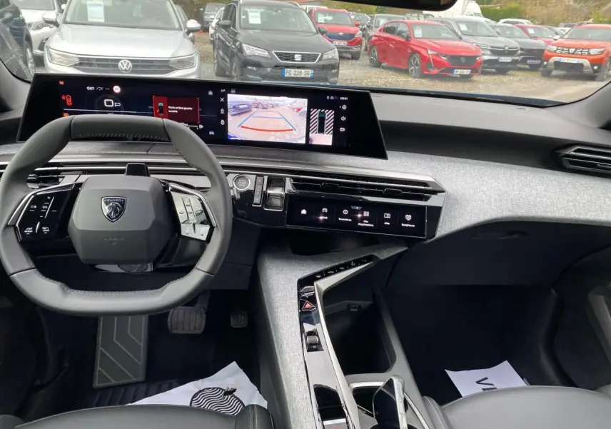 Vue intérieure avant du Peugeot 3008 Hybrid 2026 montrant le volant compact, le tableau de bord numérique incurvé et la console centrale moderne.