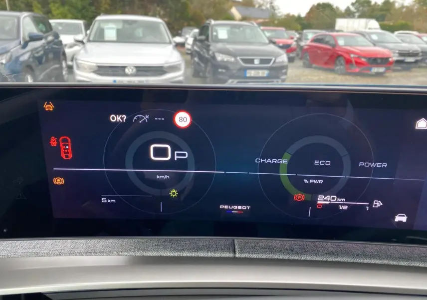 Vue intérieure du tableau de bord numérique du Peugeot 3008 Hybrid avec affichage de la vitesse et autonomie, en stationnement.