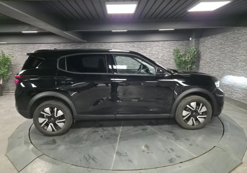 Opel Frontera-e 2025 noir métallisé vue de profil côté gauche, jantes alliage 17'' et vitres surteintées.