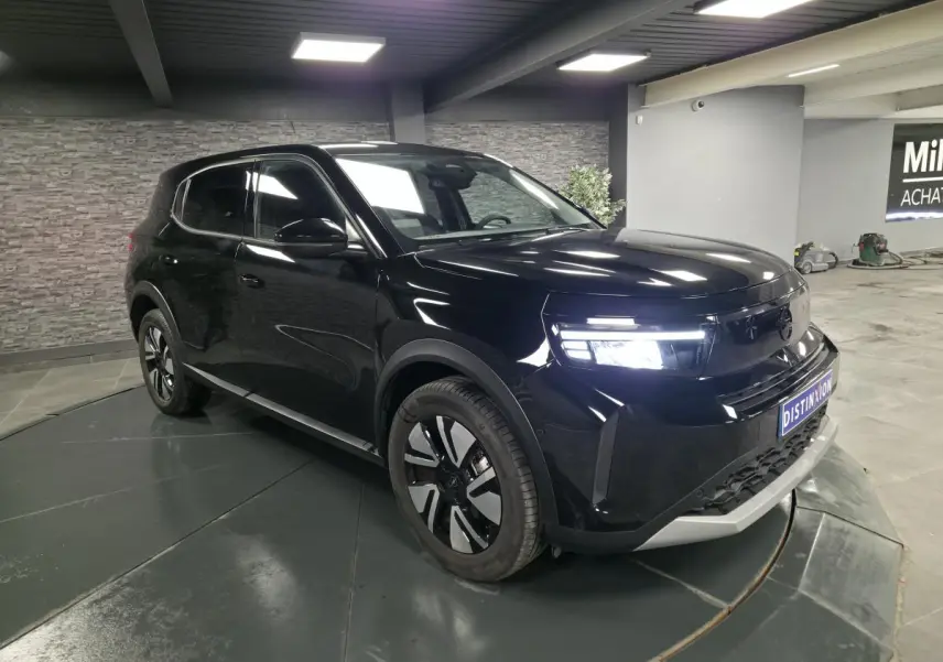 SUV Opel Frontera-e noir métallisé vu en 3/4 avant droit avec calandre Vizor et jantes alliage 17 pouces.