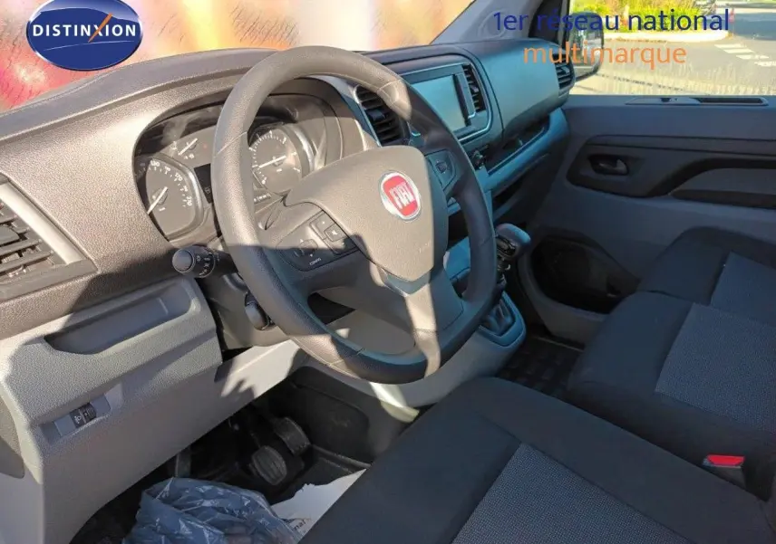 Intérieur du Fiat Scudo Fourgon 2022 montrant le tableau de bord et volant côté conducteur avec sièges tissu gris noir.