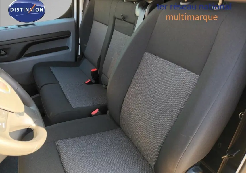 Vue intérieure côté conducteur du Fiat Scudo Fourgon 2022, sièges tissu gris et noir avec volant beige visible.