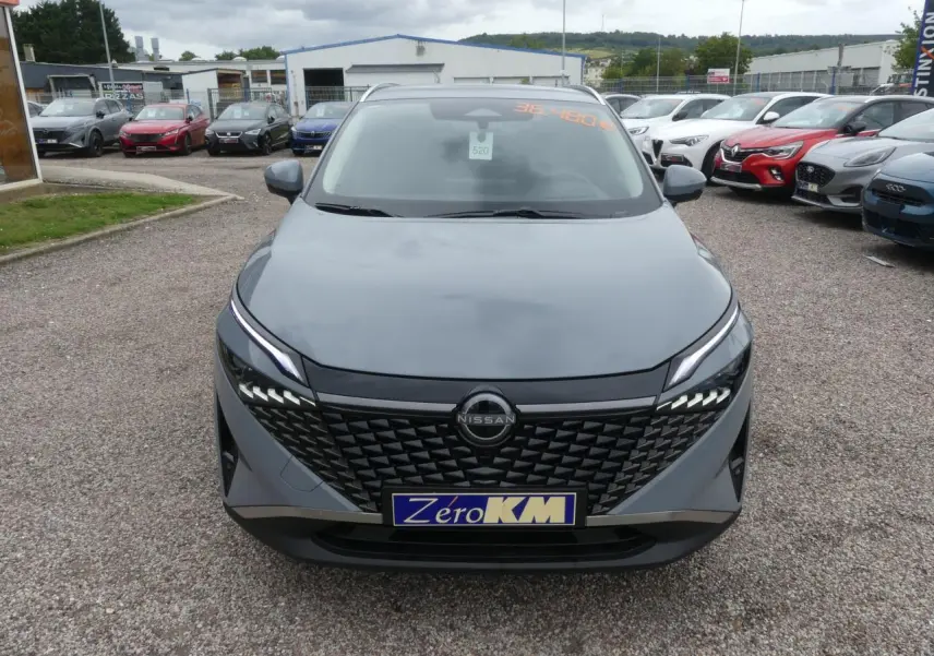 Vue frontale d'un Nissan Qashqai 1.5 e-Power gris métallisé avec calandre noire et feux LED distinctifs.