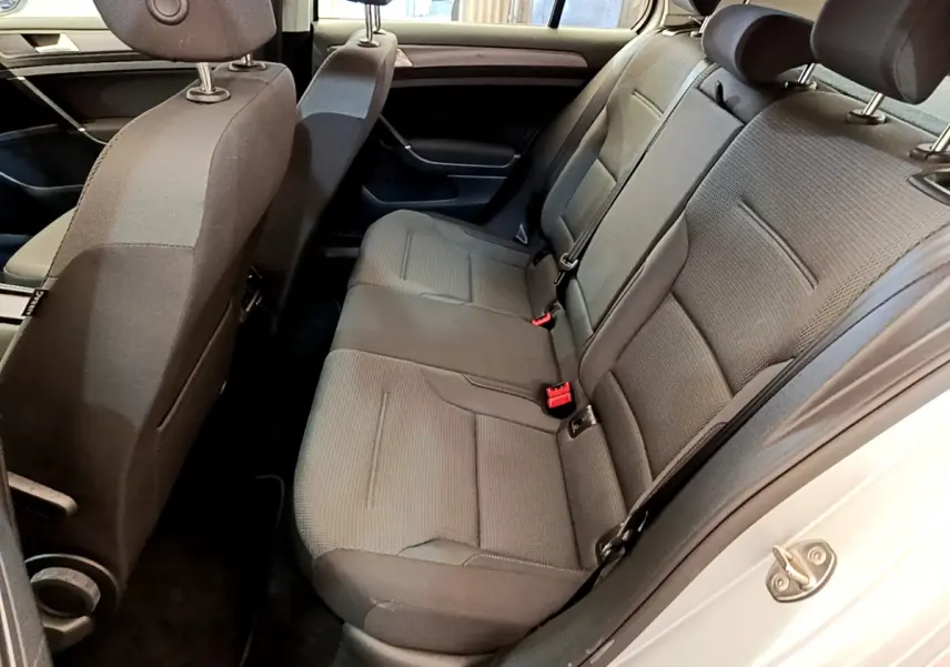 Vue intérieure côté droit montrant la banquette arrière grise et les sièges avant d'une Volkswagen Golf 2019 Confort Business.