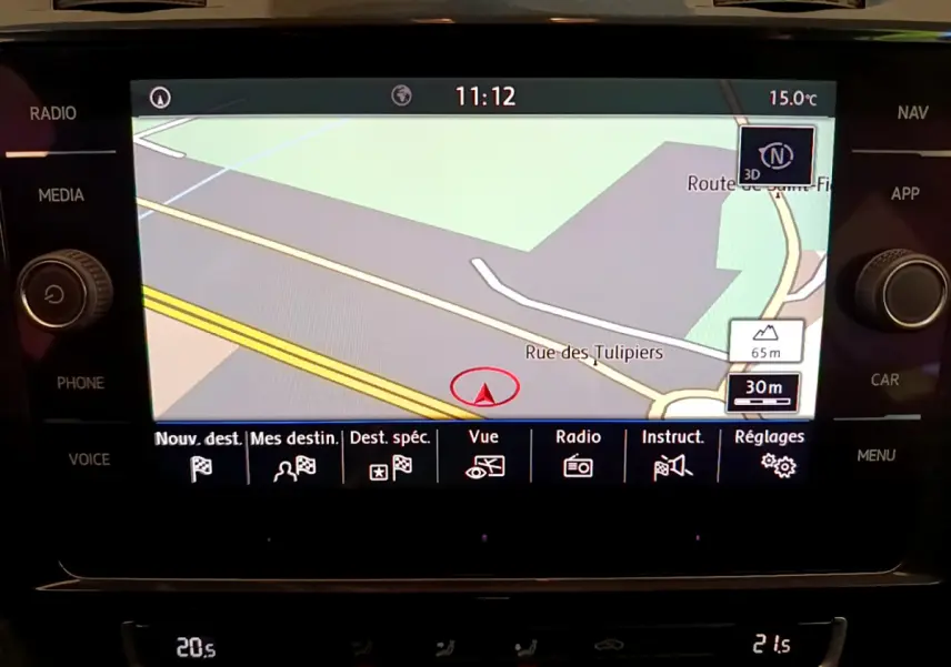Écran tactile central de navigation 3D dans Volkswagen Golf gris clair, affichant une carte routière et menus fonctionnels.