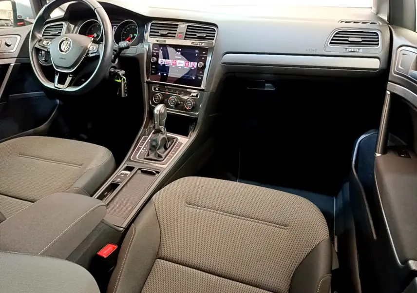 Vue intérieure avant droite de la Volkswagen Golf 1.6 TDI 2019 avec sièges gris et écran tactile central lumineux.
