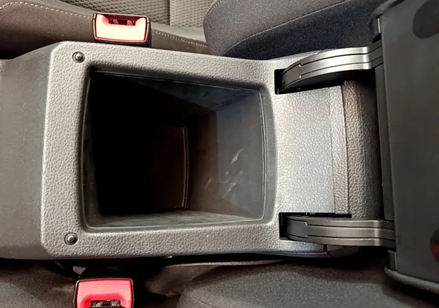 Vue plongeante sur le rangement central ouvert entre les sièges avant d'une Volkswagen Golf gris clair de 2019.