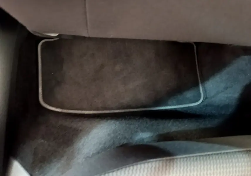 Tapis de sol noir côté passager avant d'une Volkswagen Golf 1.6 TDI gris clair, vue rapprochée intérieure.