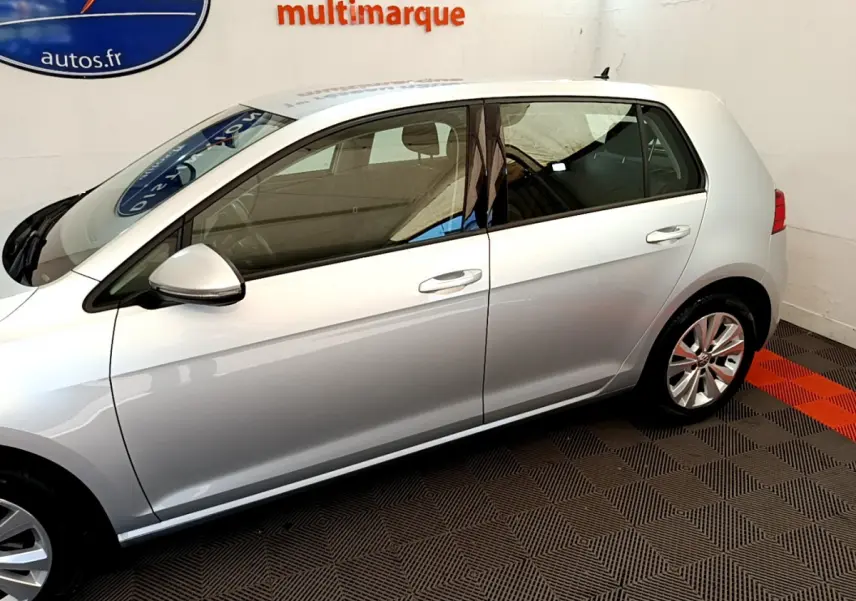 Profil côté gauche d'une Volkswagen Golf gris clair 2019, mettant en valeur ses lignes épurées et ses jantes alliage.