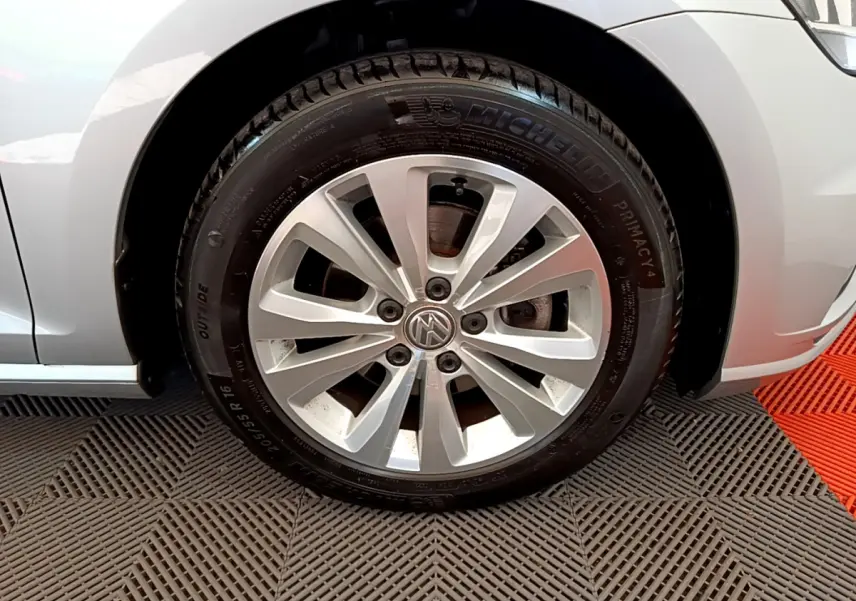 Gros plan sur la roue avant gauche gris clair d'une Volkswagen Golf 2019 avec jante alliage et logo VW central visible.