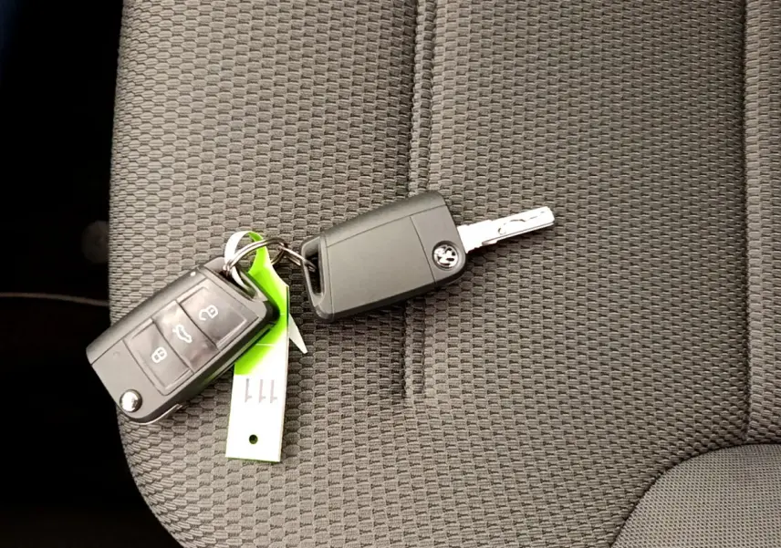 Clé Volkswagen Golf 2019 posée sur un siège tissu gris foncé, vue rapprochée de l'intérieur.