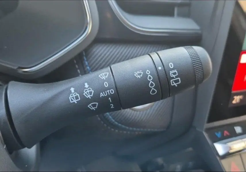 Gros plan sur la commande des essuie-glaces dans l’habitacle du Renault Captur gris Rafale, finition Esprit Alpine.