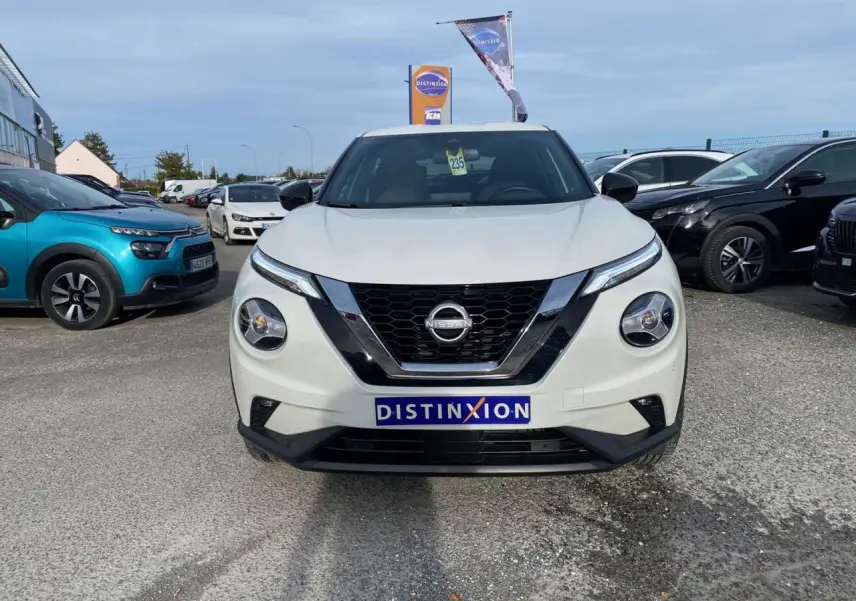 Vue frontale d'un Nissan Juke blanc perle 2024 avec calandre noire et logo Nissan bien visible.