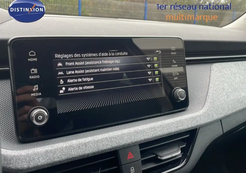 Écran central tactile du Skoda Kamiq 2025 affichant les réglages d'aides à la conduite dans un intérieur gris clair.