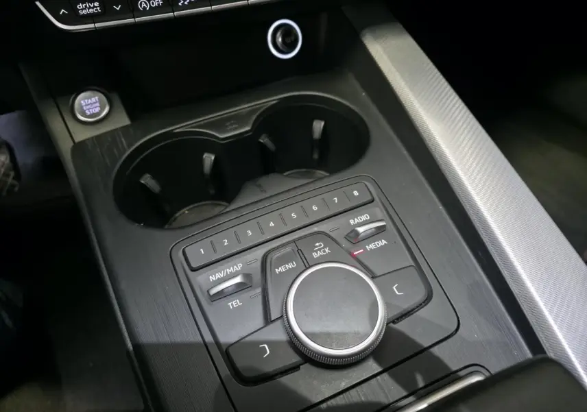 Vue rapprochée de la console centrale noire de l'Audi A4 2019 avec commandes MMI et bouton Start/Stop.