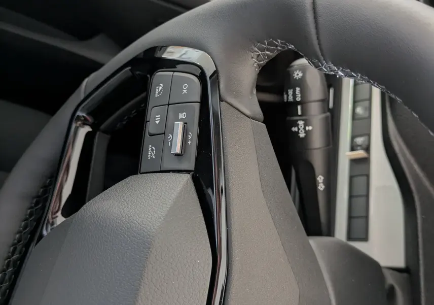 Gros plan sur le volant noir du Peugeot Traveller 2026, avec commandes intégrées et logo Peugeot visible.