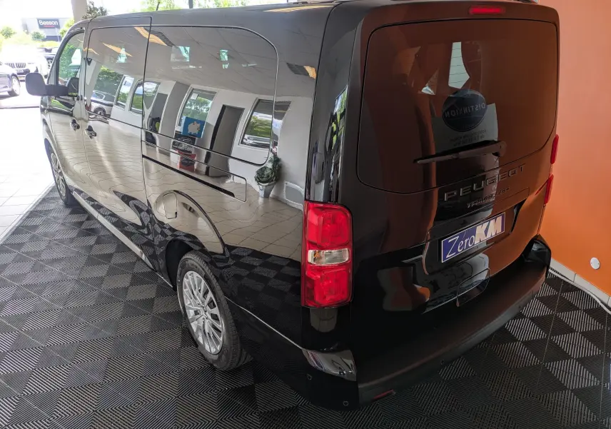 Vue 3/4 arrière droite du Peugeot Traveller noir 2026 avec hayon et vitres latérales teintées.