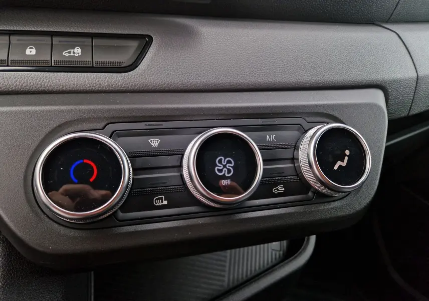 Vue rapprochée des commandes de climatisation du Renault Master 2026 gris urbain, avec boutons rotatifs et affichages lumineux.