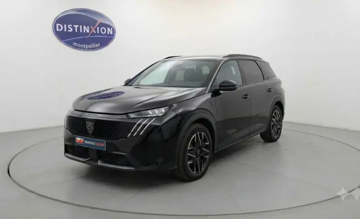 Vue 3/4 avant d’un Peugeot 5008 noir 2025 avec jantes alliage 19 pouces et barres de toit visibles en studio.
