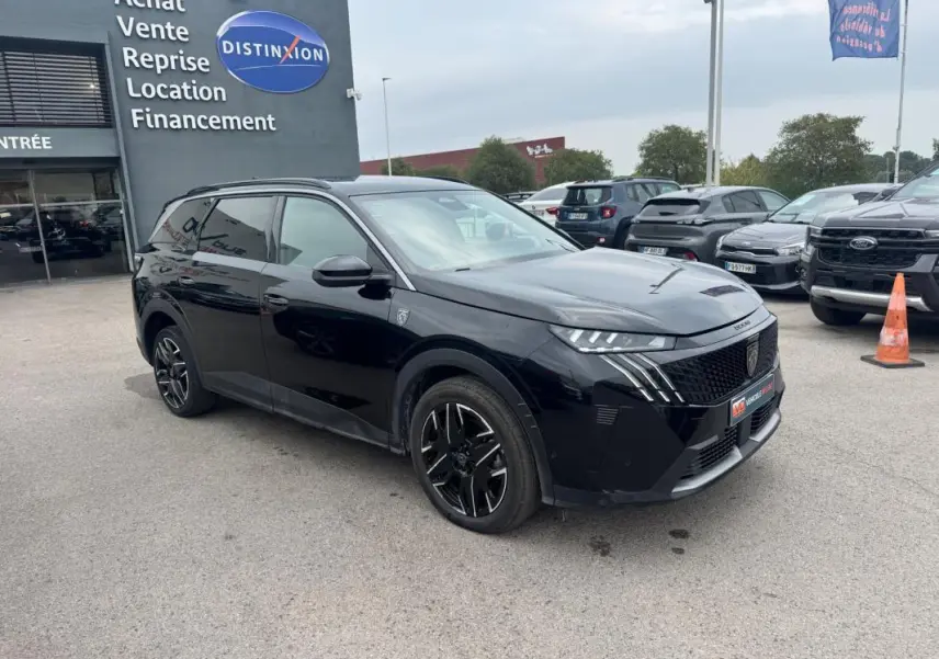 Peugeot 5008 Hybrid noir en 3/4 avant droit, avec jantes alliage noires et barres de toit visibles.