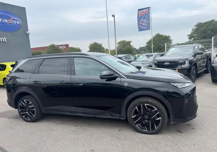 Peugeot 5008 Hybrid noir vue de profil côté gauche, avec jantes alliage noires et barres de toit visibles.