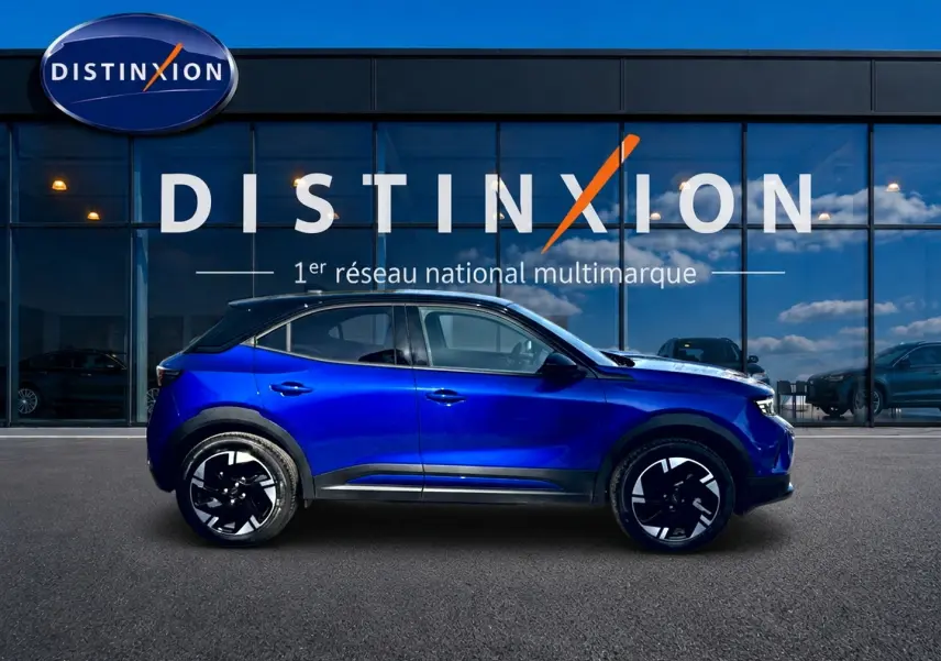 Opel Mokka Electric 156 GS bleu en profil droit devant une vitrine avec logo Distinxion.