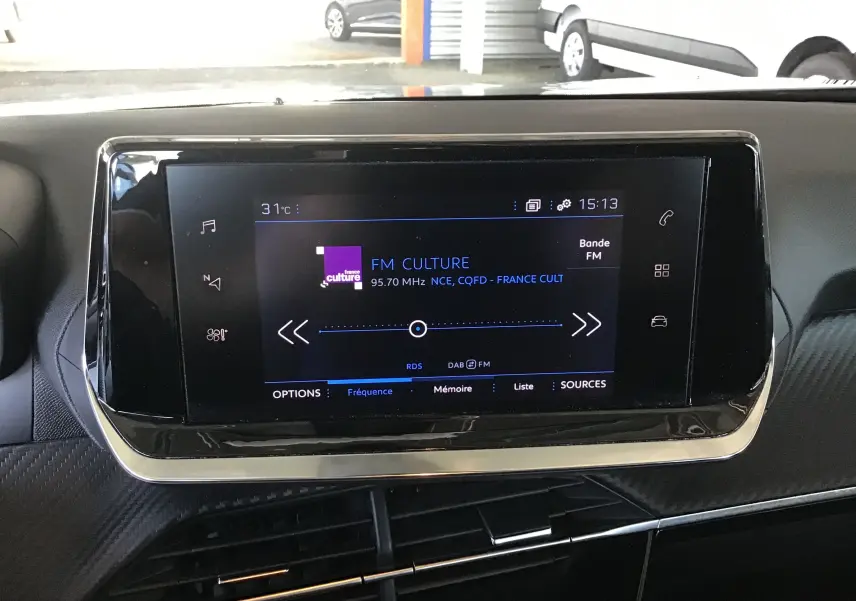 Écran tactile central du Peugeot 2008 1.5 BlueHDi 110 Active Pack GPS affichant la radio FM, intérieur noir.
