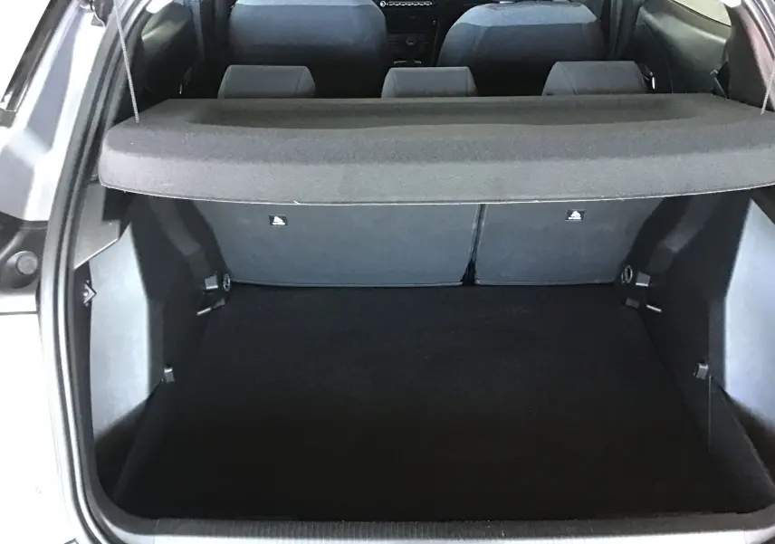 Coffre ouvert vu de l'arrière d'un Peugeot 2008 gris Artense, montrant l'espace de chargement et la banquette arrière.