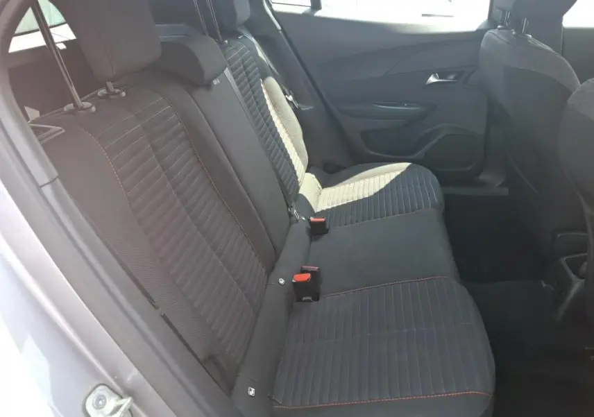 Peugeot 2008 gris Artense vue de profil côté gauche, avec toit noir et jantes alliage, stationnée sur un terrain gravillonné.
