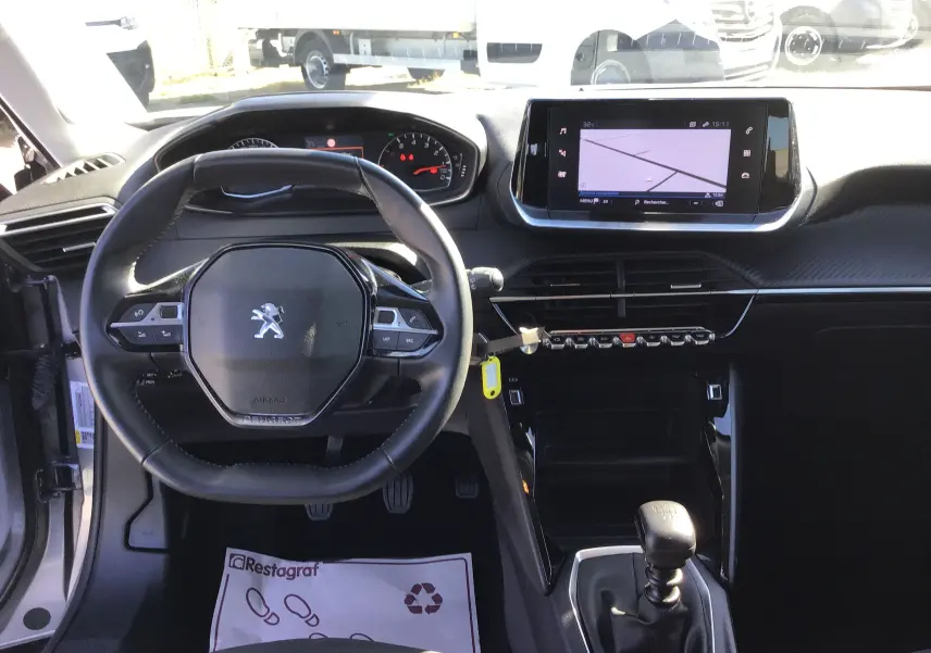 Vue intérieure avant du Peugeot 2008 1.5 BlueHDi 110 Active Pack gris, avec volant cuir, écran GPS et boîte manuelle.