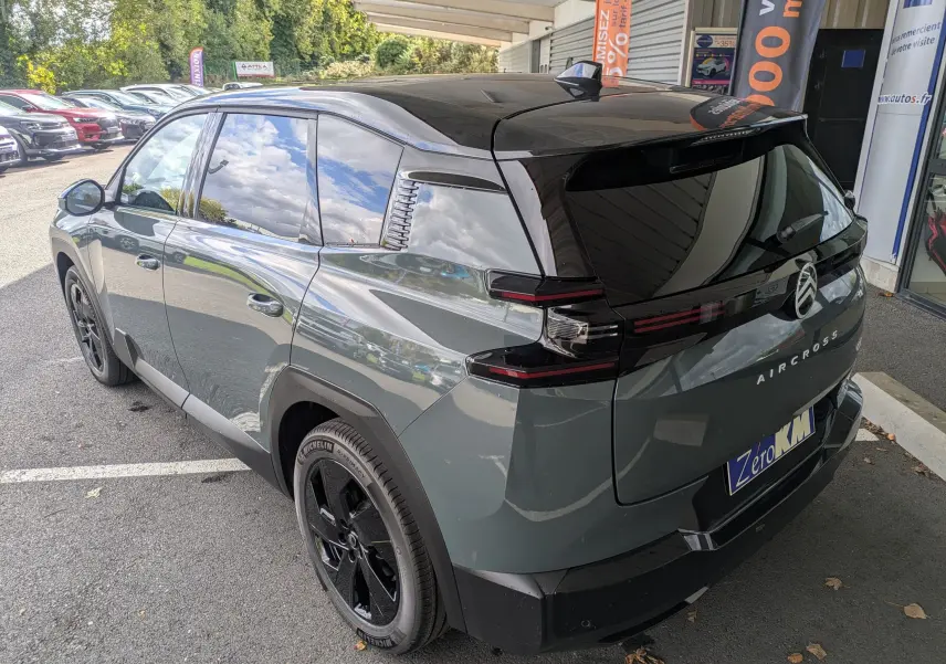 Vue 3/4 arrière droite d’un Citroën C5 Aircross hybride 2026 vert Astoria avec toit noir et jantes noires.
