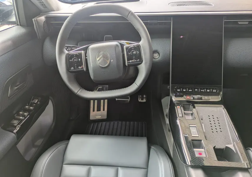 Vue intérieure centrée sur le volant et la console centrale noire du Citroën C5 Aircross hybride 2026.
