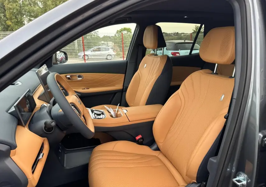 Vue intérieure côté conducteur du Geely STARRAY 1.5 EM-i 262ch Max+ en Volcanic Grey Metallic, sièges cuir camel élégants.