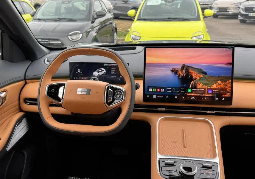 Vue intérieure du tableau de bord et volant cuir beige du Geely STARRAY 1.5 EM-i 262ch avec grand écran tactile central.