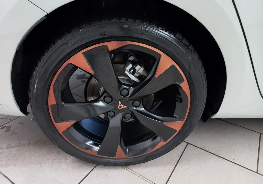 Gros plan sur la jante 18'' cuivrée et noire du CUPRA LEON ST 2025, avec partie de la carrosserie gris Taiga visible.