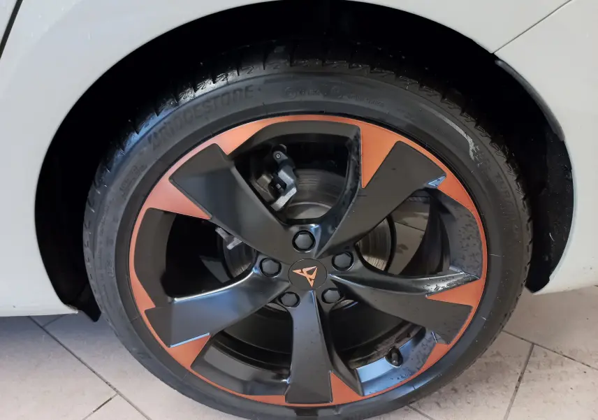 Gros plan sur la jante 18 pouces cuivrée et noire du CUPRA LEON ST 1.5 eTSI 150 DSG7 gris Taiga, côté gauche.