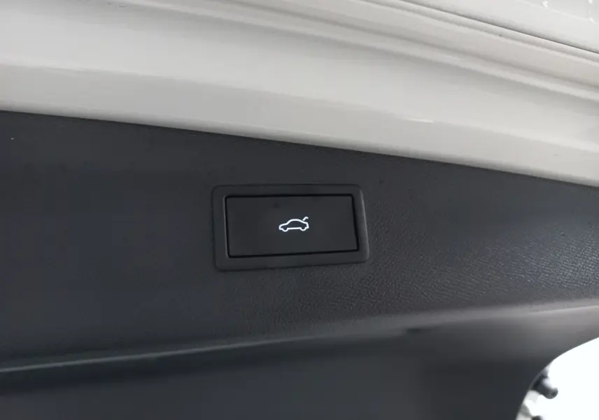 Bouton d'ouverture électrique du coffre sur la partie intérieure du hayon d'un véhicule CUPRA LEON ST gris Taiga.