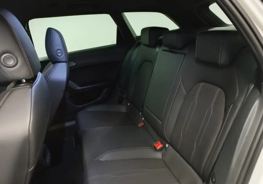 Vue intérieure arrière droite des sièges en cuir noir avec surpiqûres cuivrées du CUPRA LEON ST 2025.