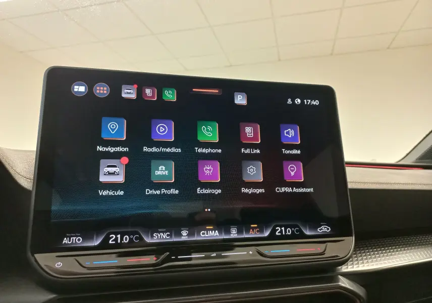 Écran tactile central du tableau de bord du CUPRA LEON ST 1.5 eTSI 150 DSG7 V avec interface multimédia et climatisation digitale.