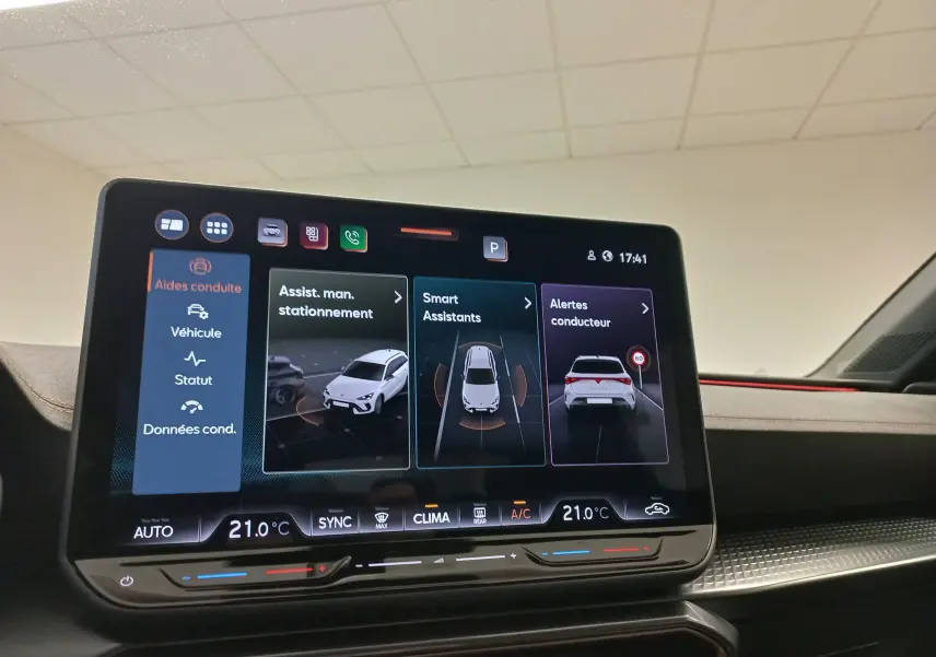 Écran tactile intérieur du CUPRA LEON ST 2025 affichant les aides à la conduite et la climatisation à 21°C.